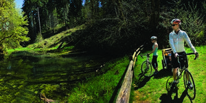 A family rests at Beaver Pond before continuing on their bike tour through Stub Stewart Park.