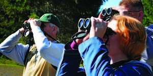 Volunteers assist a family in identify native birds habitating around the Stub Stewart State Park.